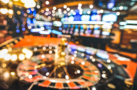 Blurred defocused background of roulette at casino saloon – Gambling concept with unfocused game room with video poker slot machines and multicolored blurry lights